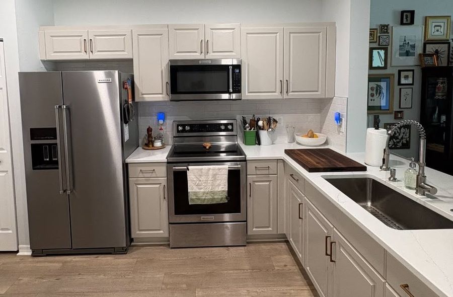 Finished kitchen with white cabinets, stainless appliances, subway tile backsplash and butcher-block counter by NoBull Man